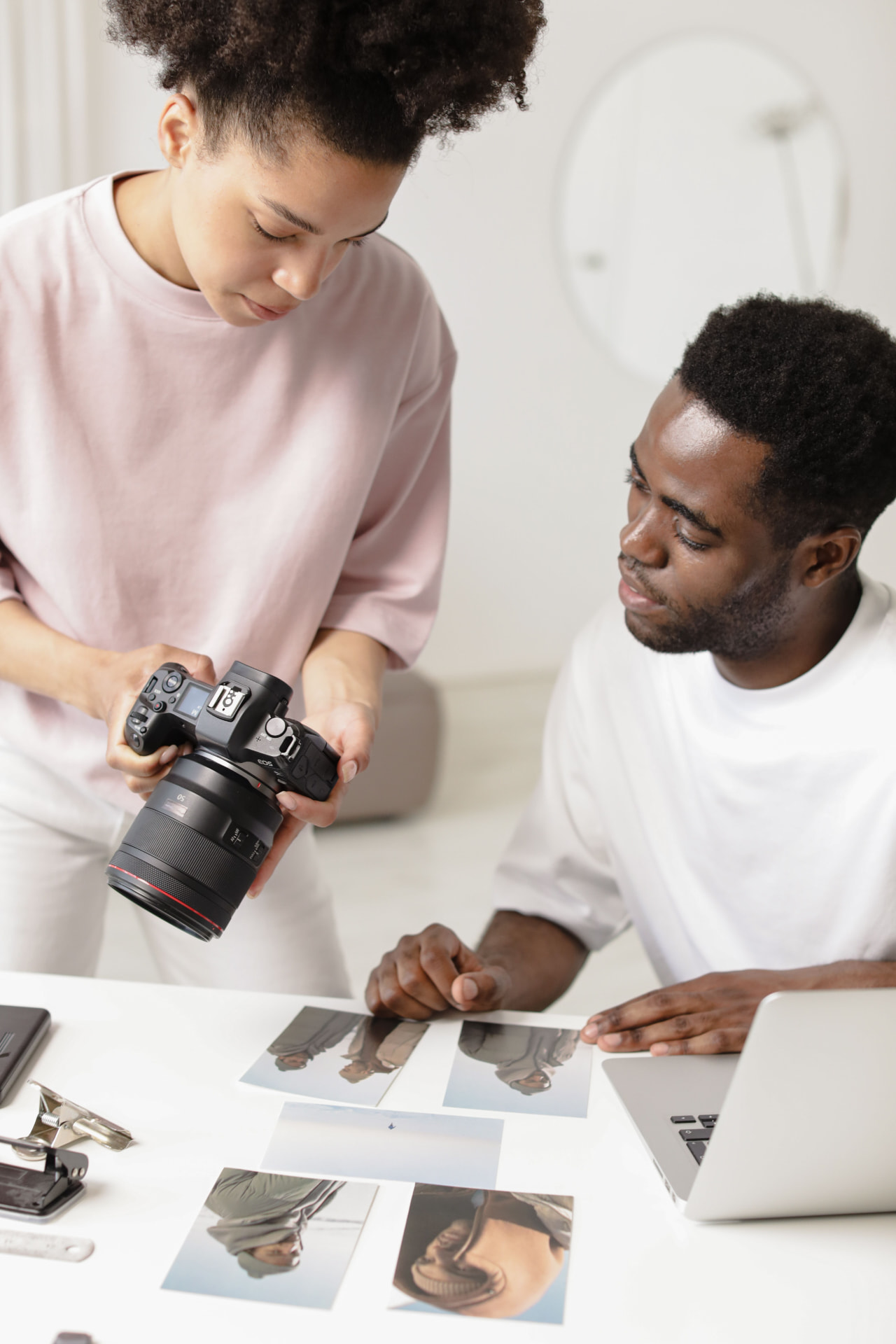 A photographer reviewing portrait prints with a client at a studio table